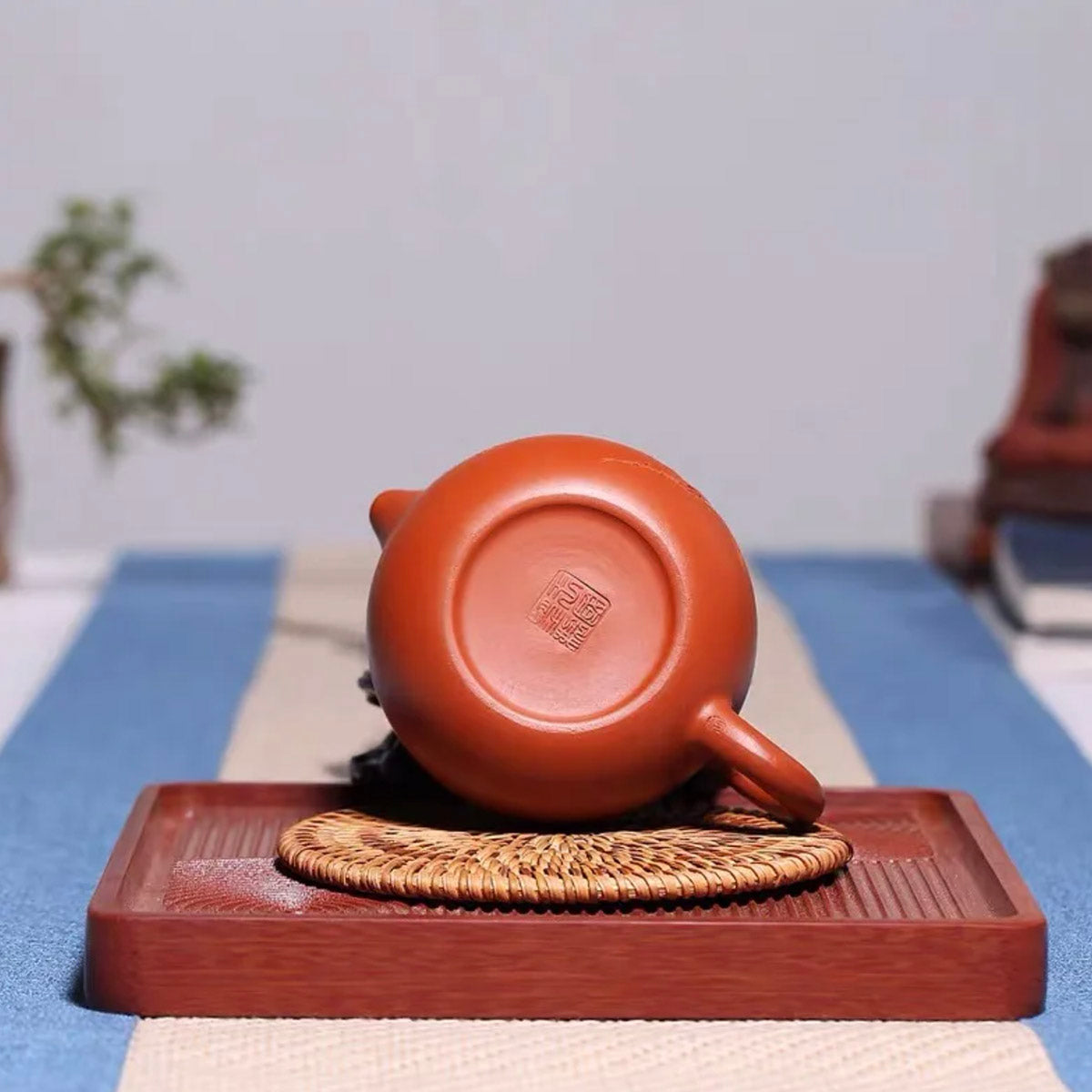 Ceramic teapot on a wooden tray with a blurred background